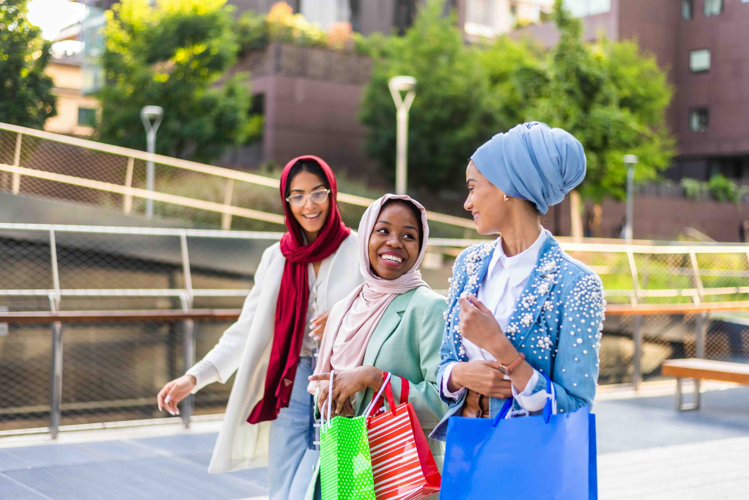Multiethnic group of muslim girls wearing casual clothes and traditional hijab bonding and having fun outdoors - 3 arabic young girls